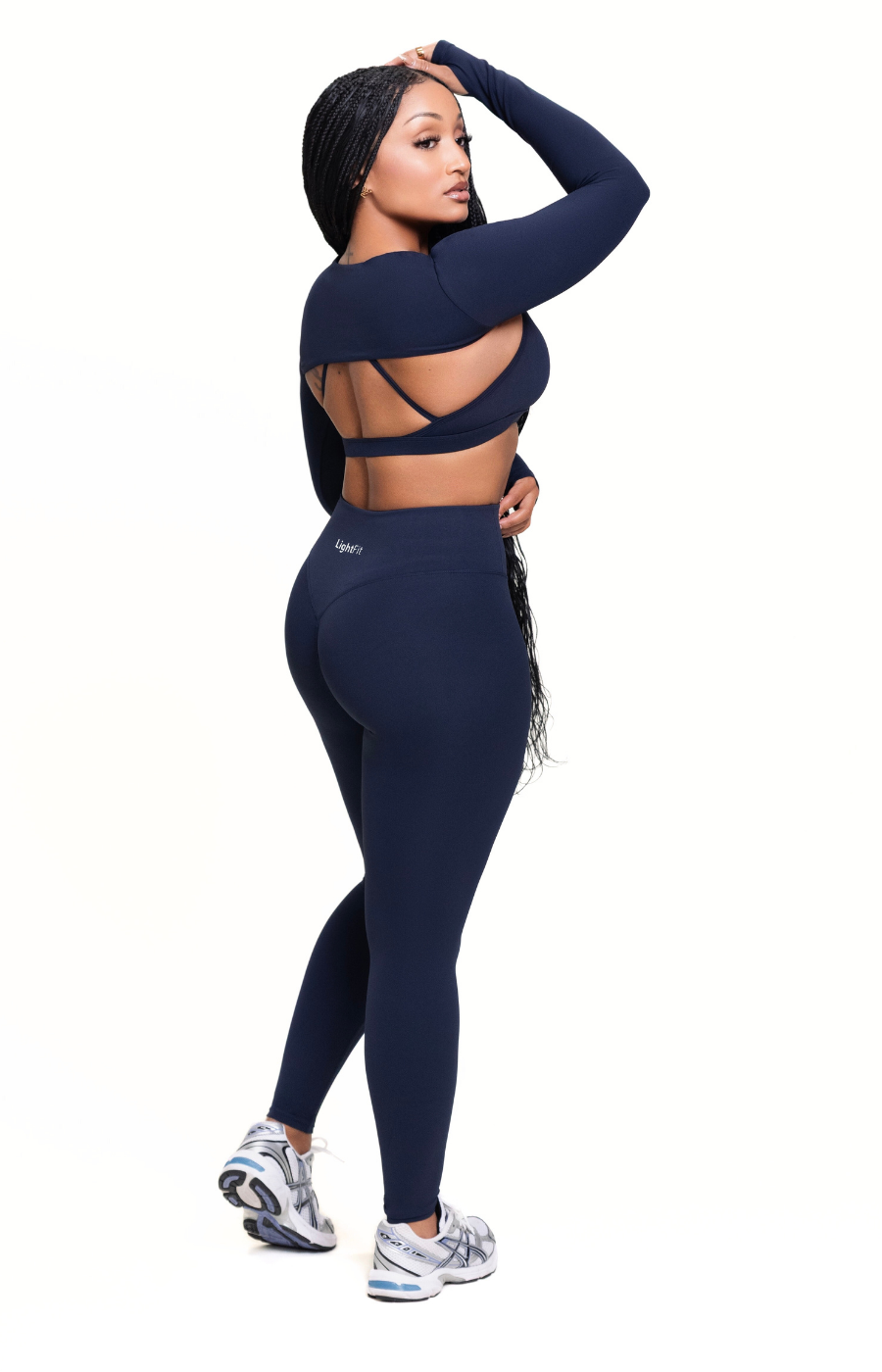 Woman wearing a navy blue athletic outfit on a white background