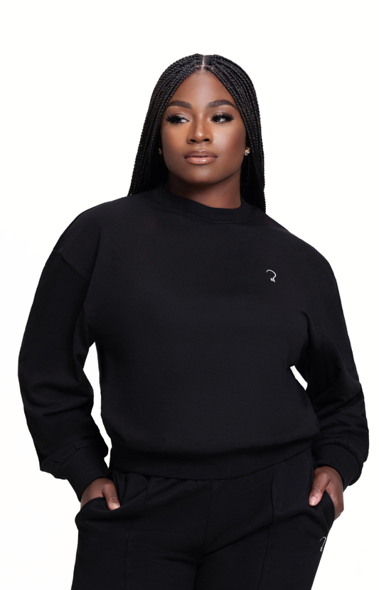 Woman wearing a black sweatshirt with a small logo on a white background