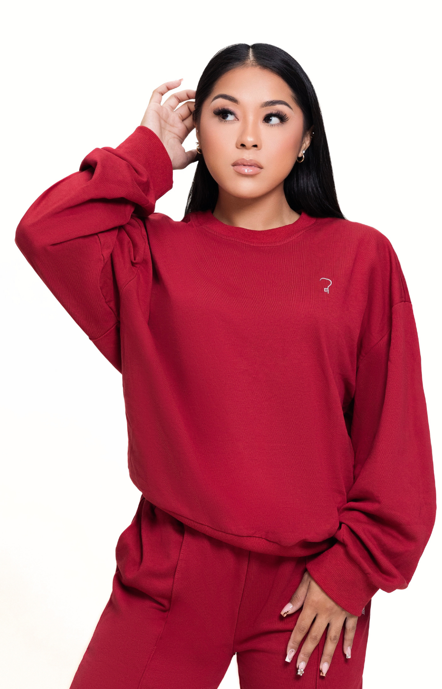 Woman wearing a red sweatshirt with a small logo on a white background